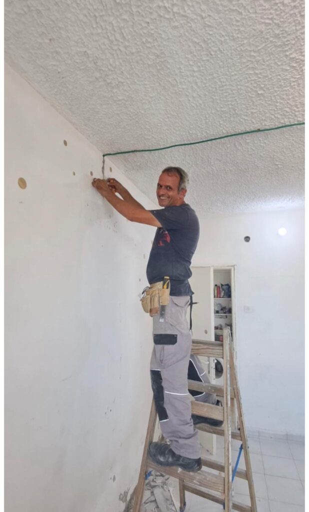 Man standing on ladder working on dry wall